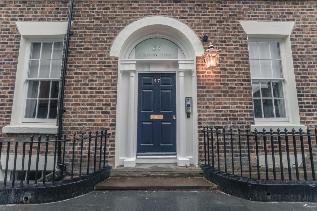 a blue door on a brick building with two windows at Clarence Street Town House in Liverpool