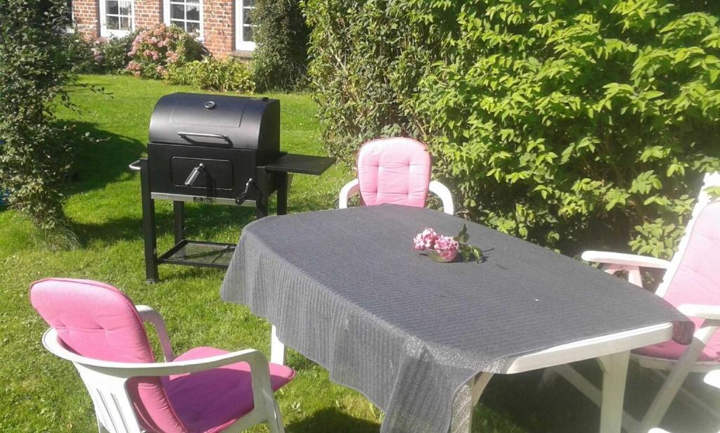 a table and chairs with a bbq and a grill at Ferienwohnung Petersen-Kröger in Gelting