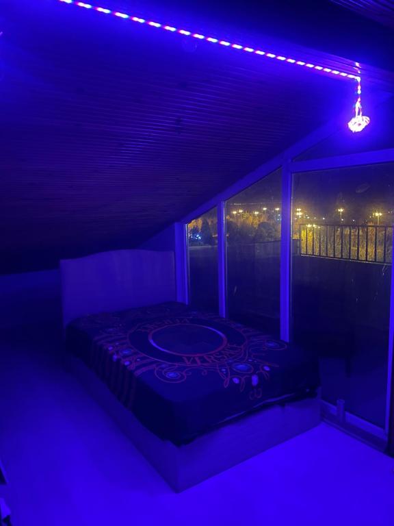 um quarto com uma cama num quarto com luzes azuis em Suit tuzla em Tuzla