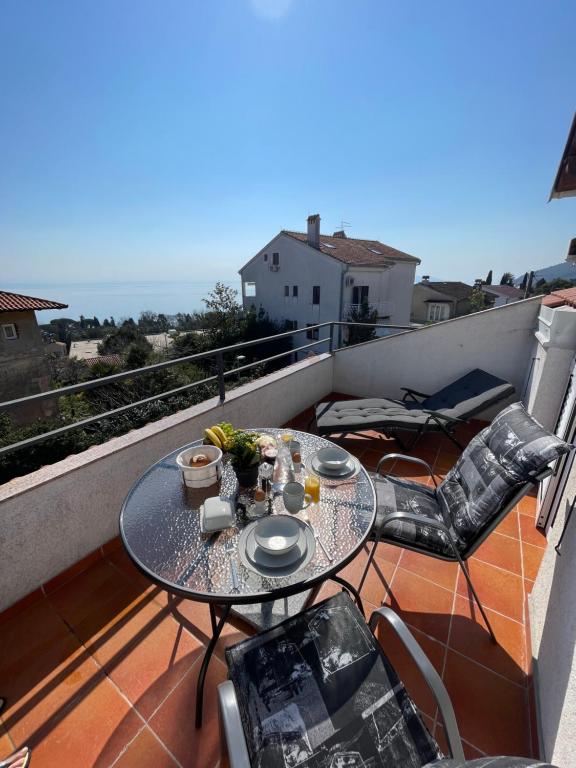 a balcony with a table and chairs on a roof at Apartment Lady Daniela mit Meerblick in Lovran in Lovran