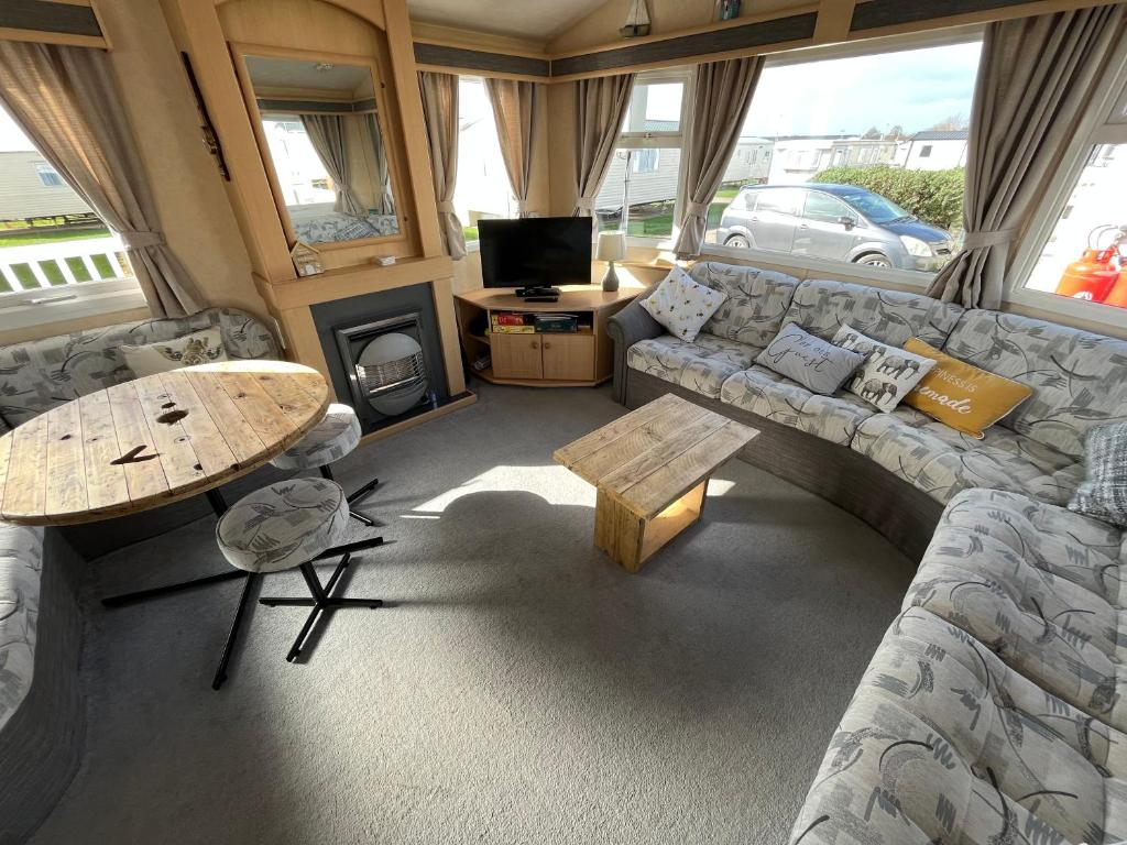 a living room with a couch and a table at Grouse 54, Scratby - California Cliffs, Parkdean, sleeps 6, pet friendly, bed linen, towels and Wi-Fi included in Scratby