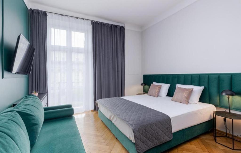 a bedroom with a large bed and a couch at Angel apartmens in Wrocław