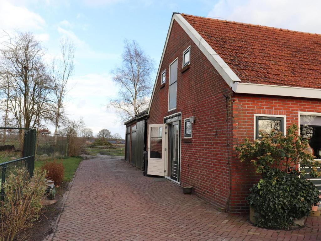 uma casa de tijolos vermelhos com uma entrada de tijolos em Welcoming holiday home in Donkerbroek with parking em Donkerbroek