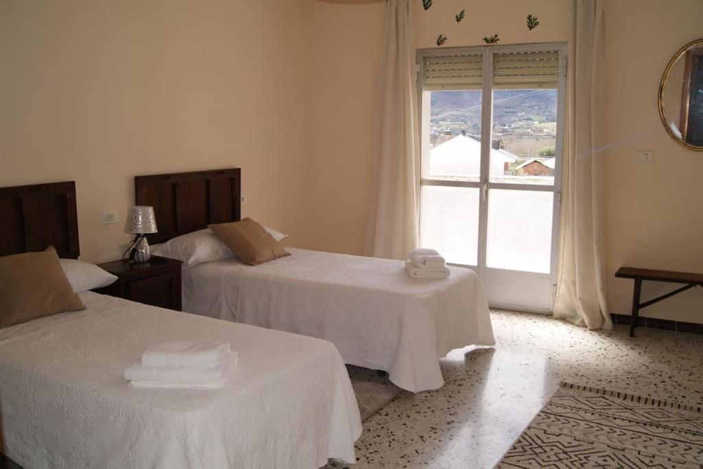 a hotel room with two beds and a window at Dona Branca in Quiroga