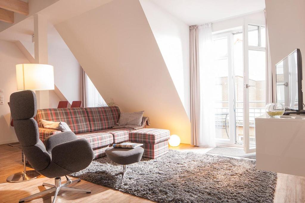 een woonkamer met een bank en een stoel bij Villa Brunnenhof 06 in Norderney