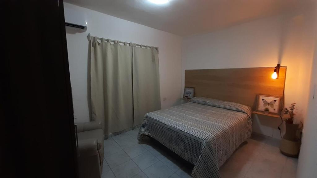 a small bedroom with a bed and a shower at DEPARTAMENTO LAPRIDA in La Banda