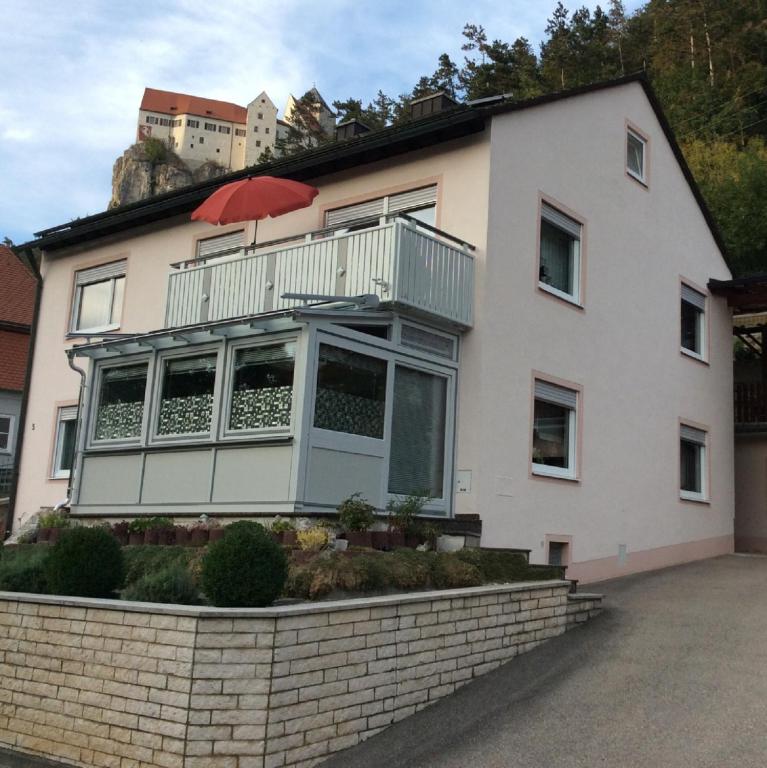 a white house with a balcony on top of it at Ferienwohnung Renate Pfaller in Riedenburg