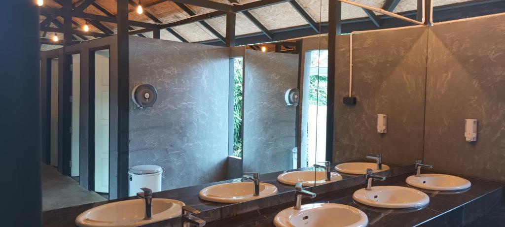 una fila de lavabos en un baño público en The Triple M Mountain Resort en Ban Muang Ton Mamuang