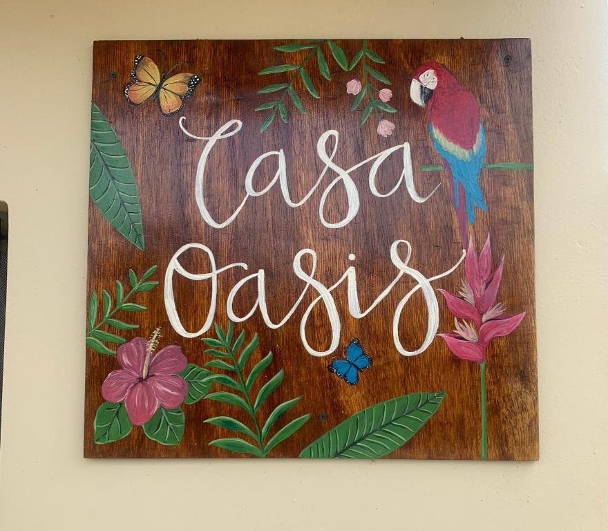 una señal de madera con un pájaro y una señal que saysla casitas en Casa Oasis, en Leticia