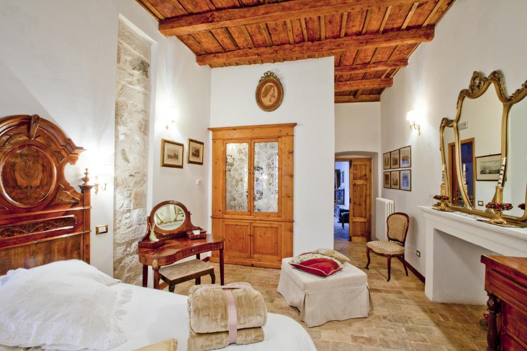 um quarto com uma cama, uma secretária e um espelho em B&B Il Marchese Del Grillo em Sulmona