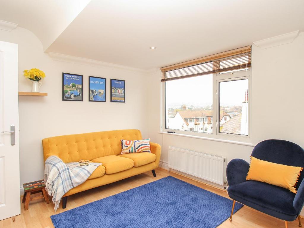 a living room with a couch and two chairs at Nine Barrow View in Swanage