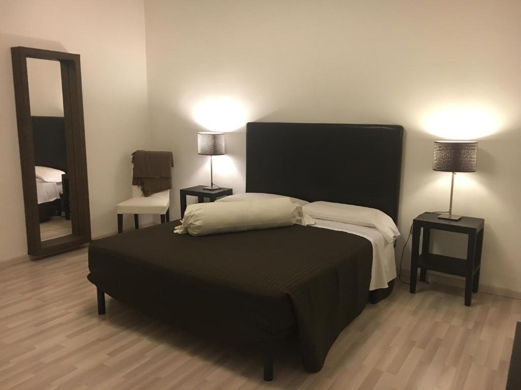a bedroom with a bed and two lamps and a mirror at Sunday Apartments in Mestre