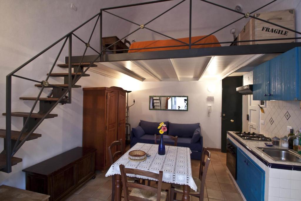 Habitación con mesa de comedor y cama elevada. en 4Roomsrelax, en Catania