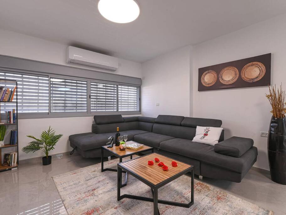 sala de estar con sofá y mesa en פנטהאוז רפאל - פנטהאוז עם 3 חדרי שינה ומרפסת - יש מקלט בקרבת המקום, en Beit She'an