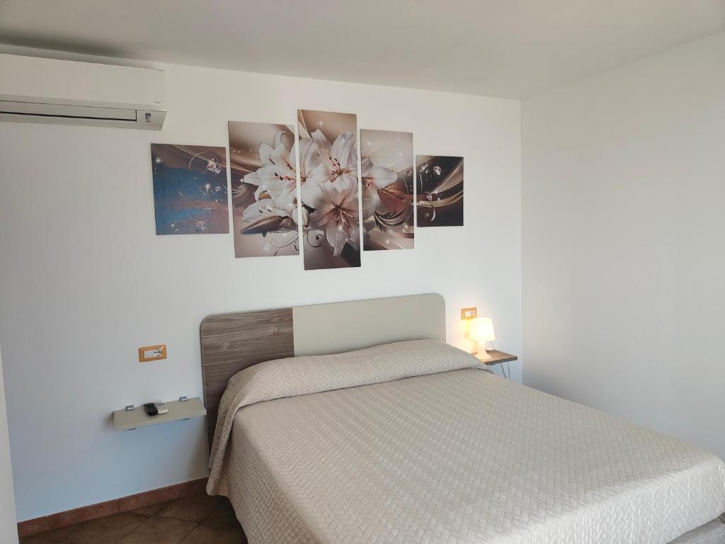 una camera da letto con un letto con quattro dipinti sul muro di B&B Oliva a Scala