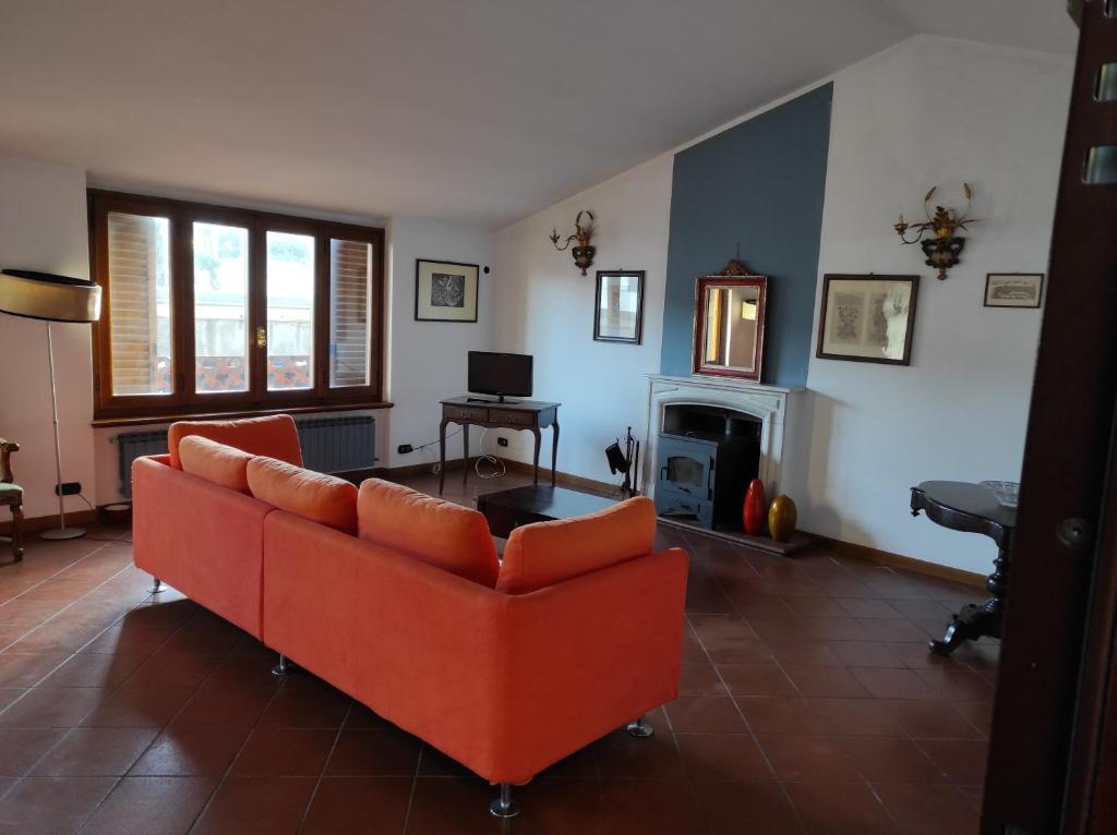 a living room with an orange couch and a fireplace at Sea Breeze in Viareggio
