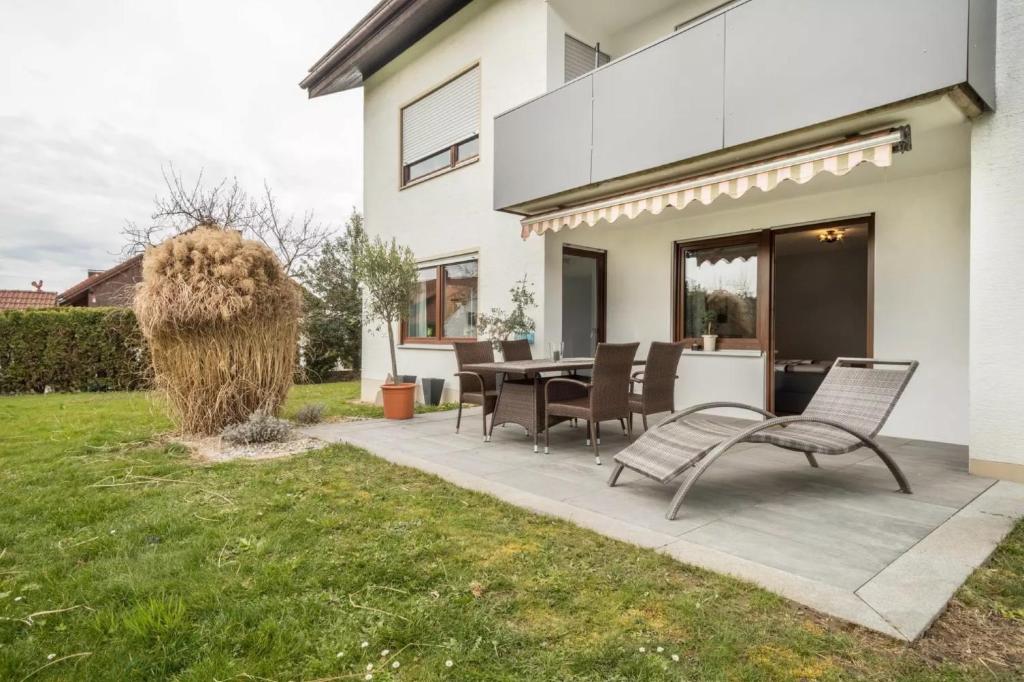 d'une terrasse avec une table et des chaises dans la cour. dans l'établissement Fewo Hotz am Golfclub Lindau 2b, à Lindau