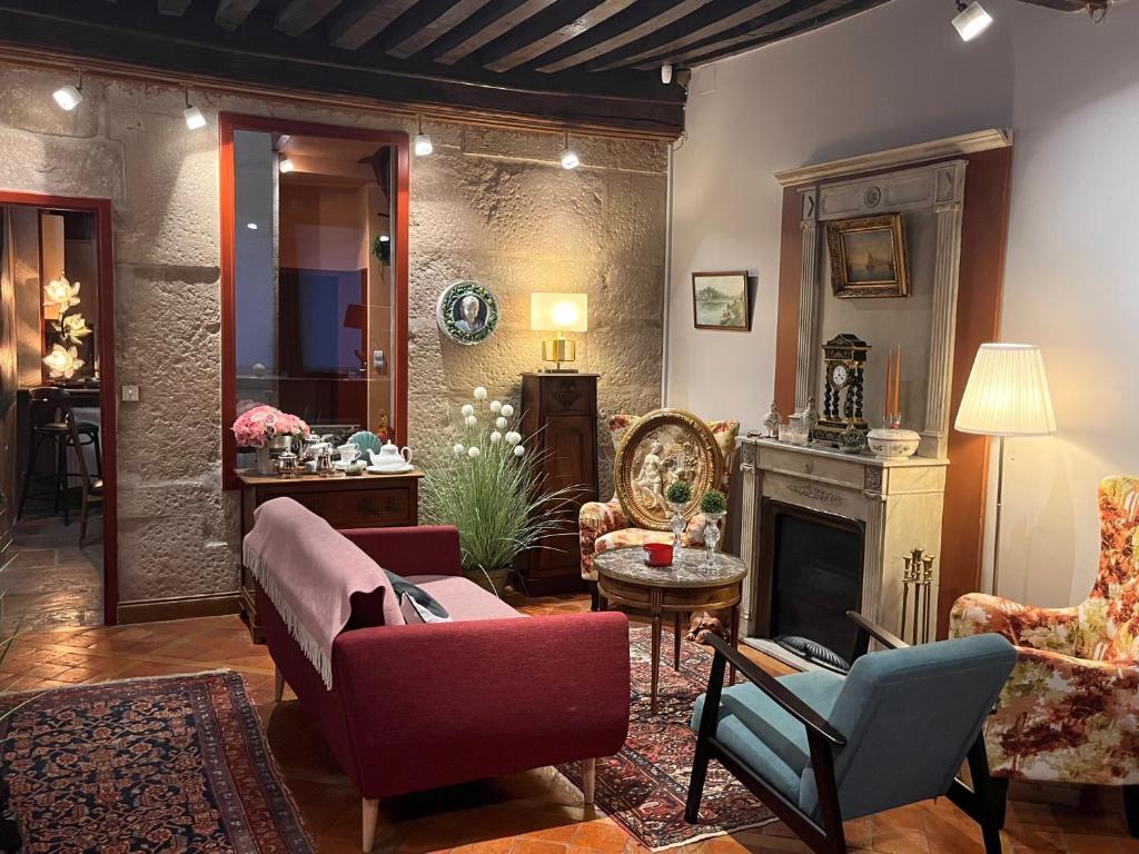 een woonkamer met een bank en een open haard bij COSY POTET in Dijon