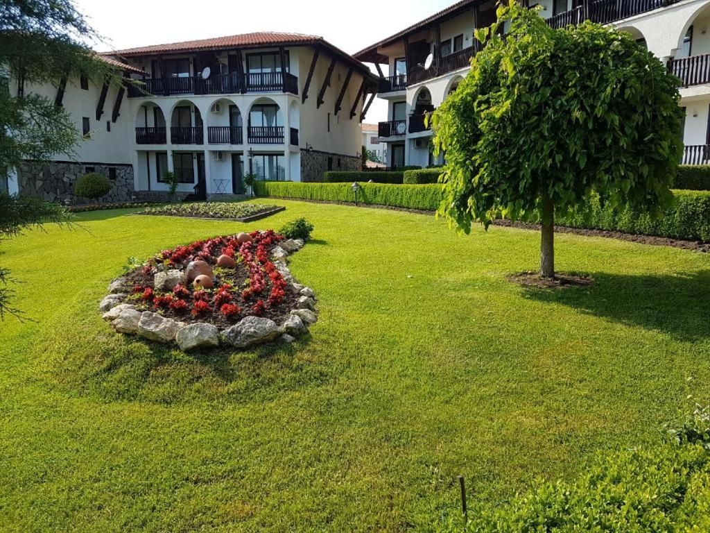 een tuin met een bloemstuk in het gras bij Monastery Apartment 14, St. Vlas in Sveti Vlas