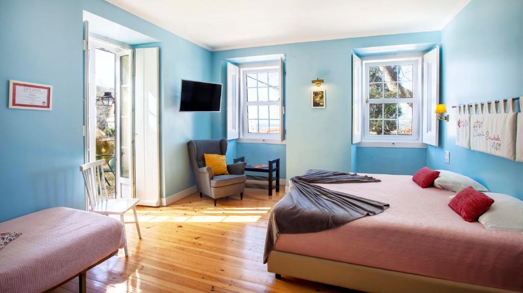 um quarto azul com 2 camas e uma cadeira em Casa do Vinho Sintra Guest House em Sintra