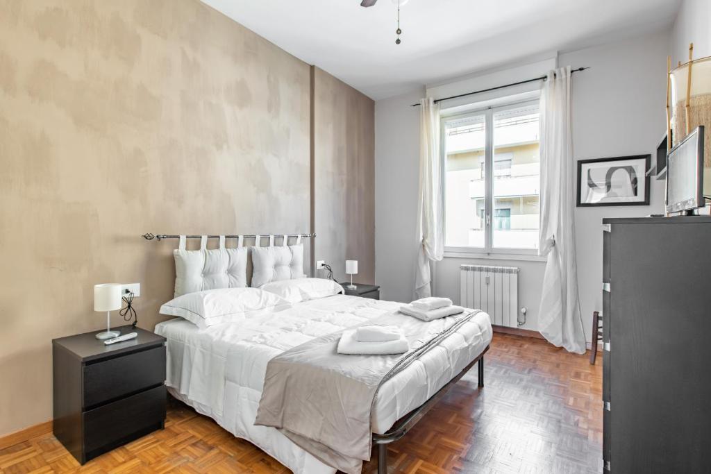 Florence Modern & Bright Apartment! في فلورنسا: غرفة نوم بسرير ابيض كبير ونافذة