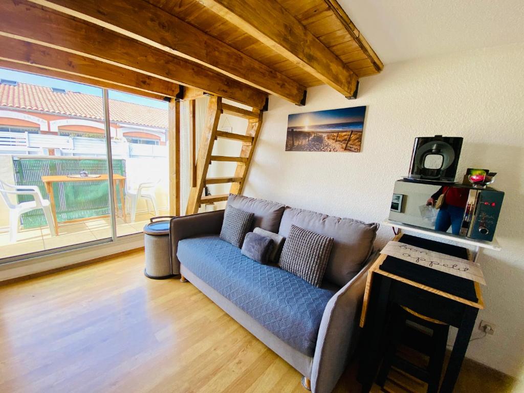 salon z kanapą i dużym oknem w obiekcie ''Ophélia 133'' Cosy studio climatisé avec balcon w mieście Sète