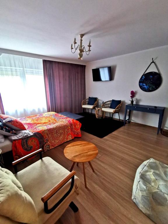 ein Wohnzimmer mit einem Bett und einem Tisch in der Unterkunft Butikowe Pokoje Zdrój Głuchołazy in Głuchołazy