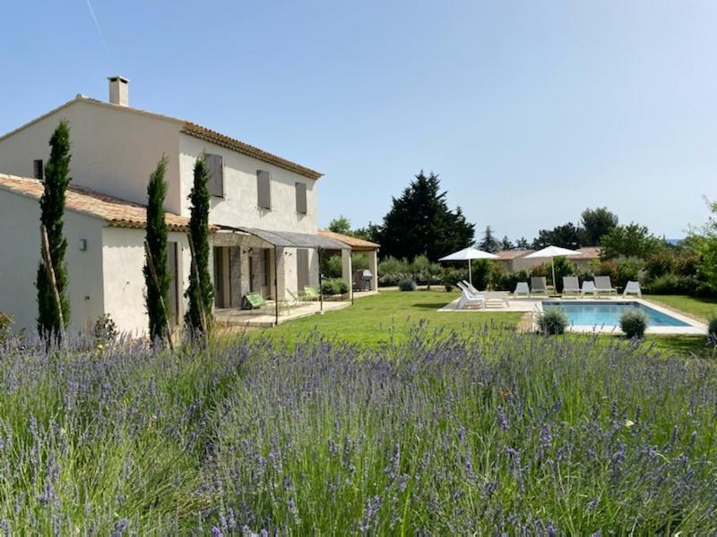 een huis met een tuin en een zwembad bij Bastide la Melonnerie in Lacoste