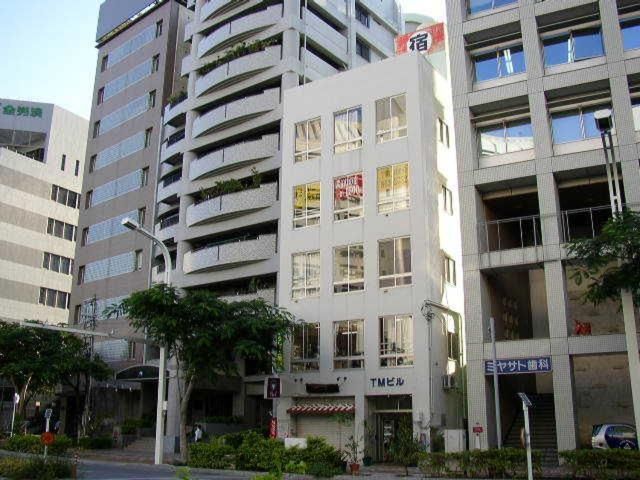 un gran edificio blanco con muchas ventanas en una ciudad en Grace Naha, en Naha