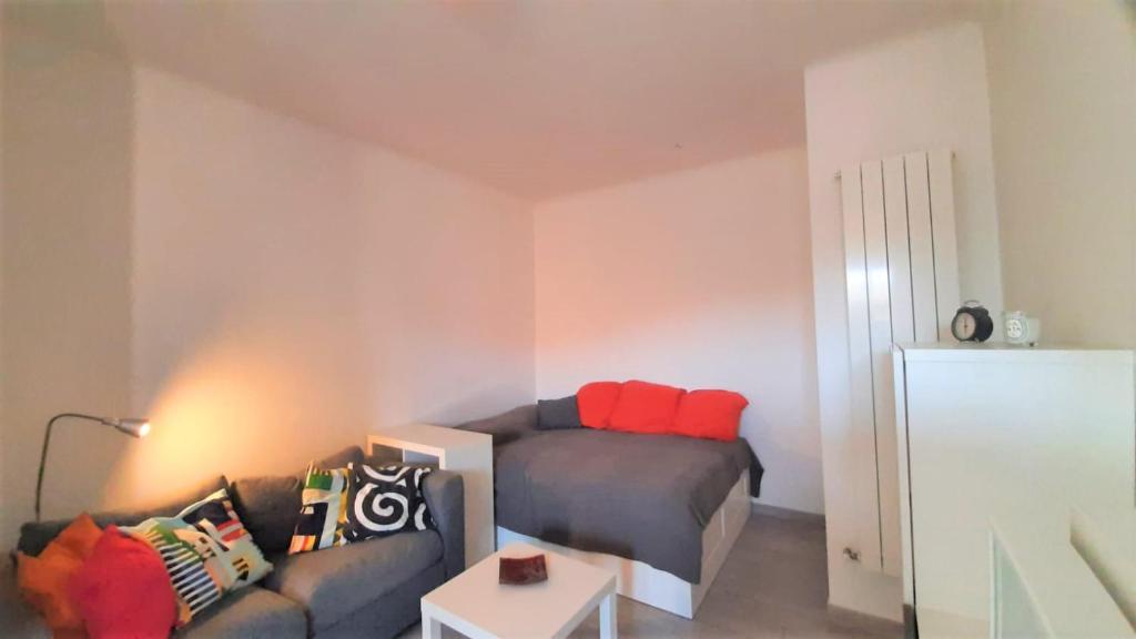 ein Wohnzimmer mit einem Bett und einem Sofa in der Unterkunft Accomodo MIM23 Monolocale Navigli in Mailand