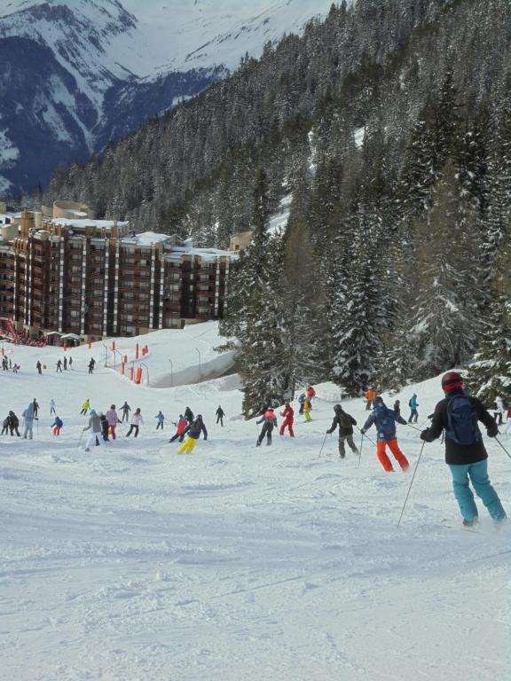un groupe de personnes skier sur une piste enneigée dans l'établissement MON SKI A LA PLAGNE - PLAGNE BELLECOTE Résidence 3000, à Plagne Bellecôte