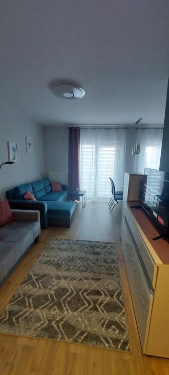 un soggiorno con divano blu e tappeto di Sweet Home Legionów Apartment a Łódź