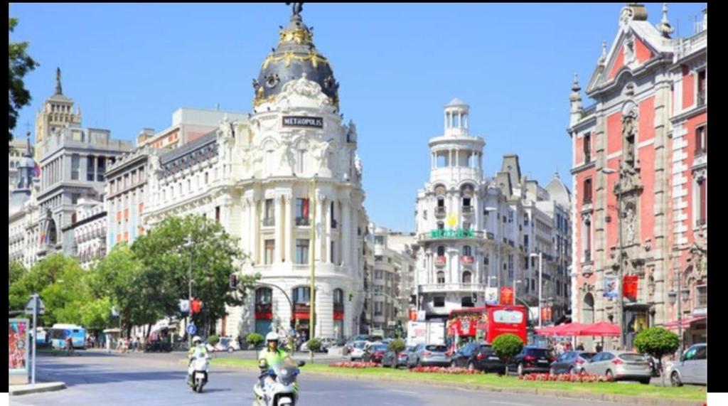 una calle de la ciudad con edificios y gente en motocicleta en HOSTAL ANDREA SOL, en Madrid
