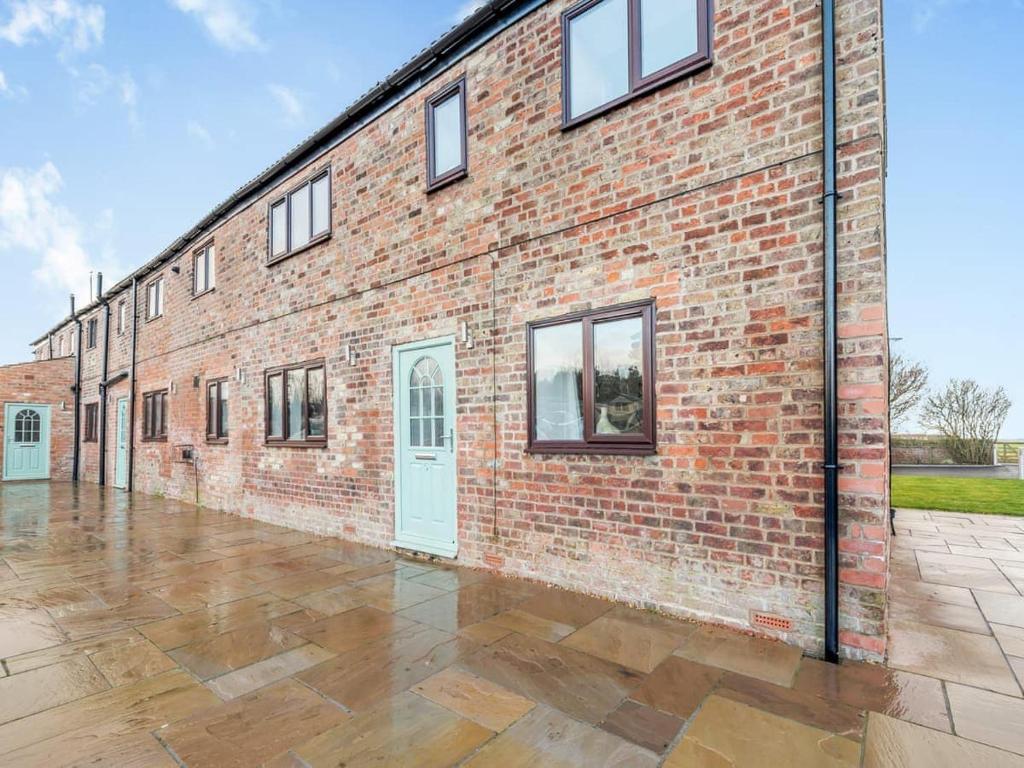 um edifício de tijolos com portas brancas e piso de azulejo em Beautiful 3 Bedroom Cottage -Cottage 5 em Doncaster