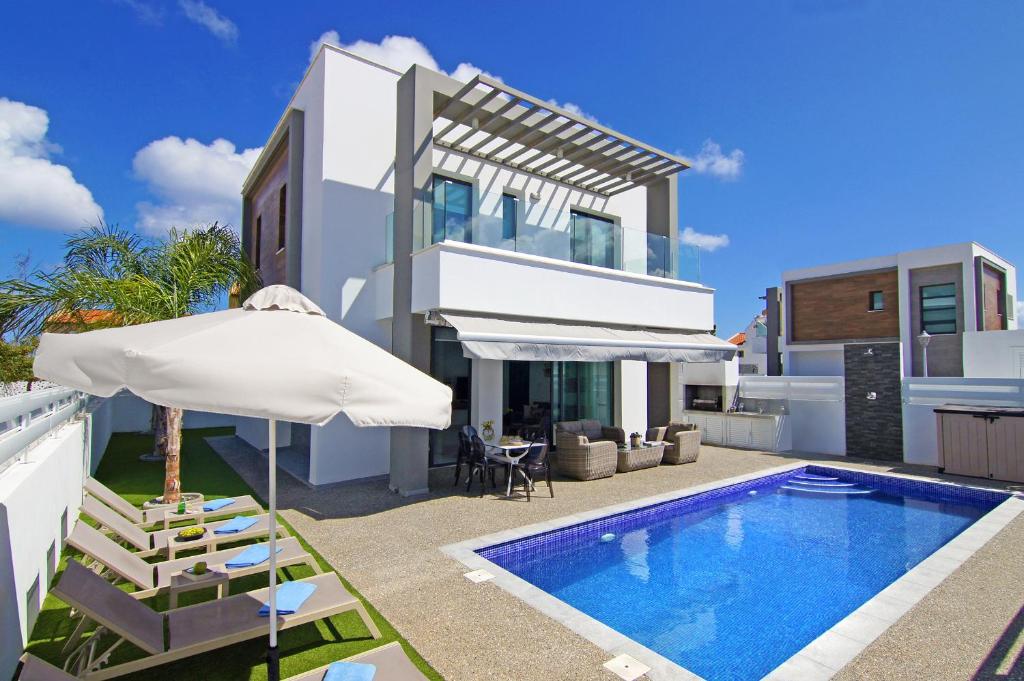 uma villa com uma piscina e um guarda-sol em Villa Martha em Protaras