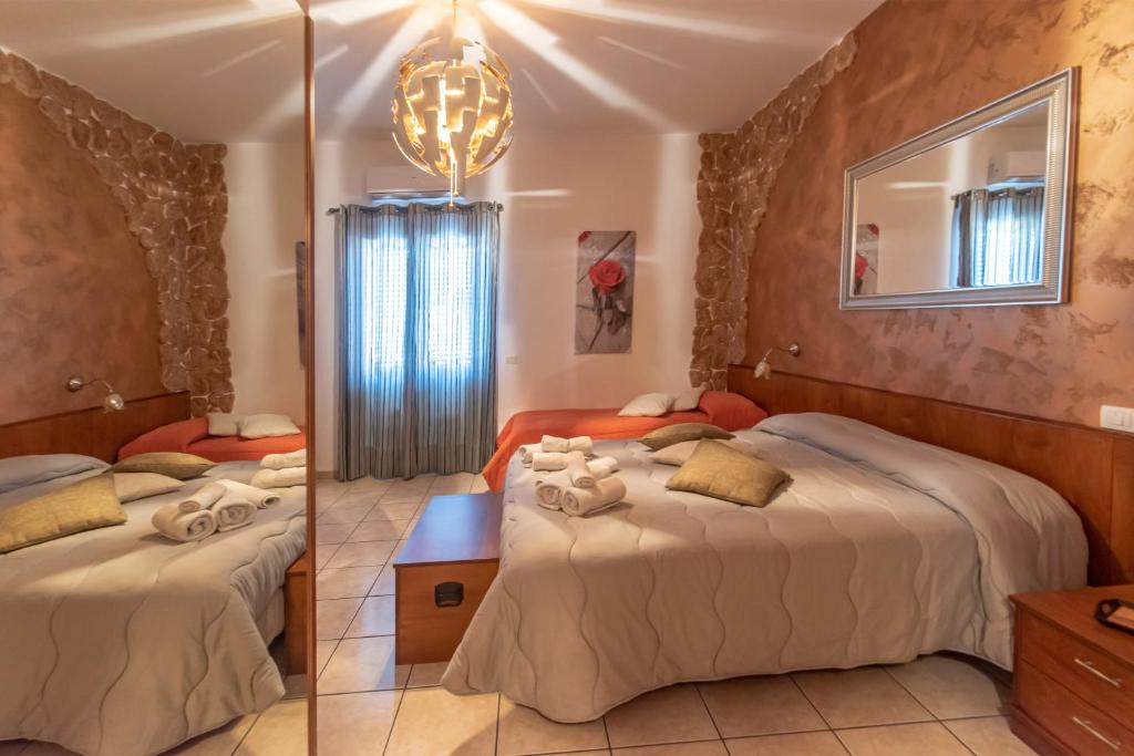 Habitación de hotel con 2 camas y espejo en Spiagge Iblee, en Marina di Ragusa