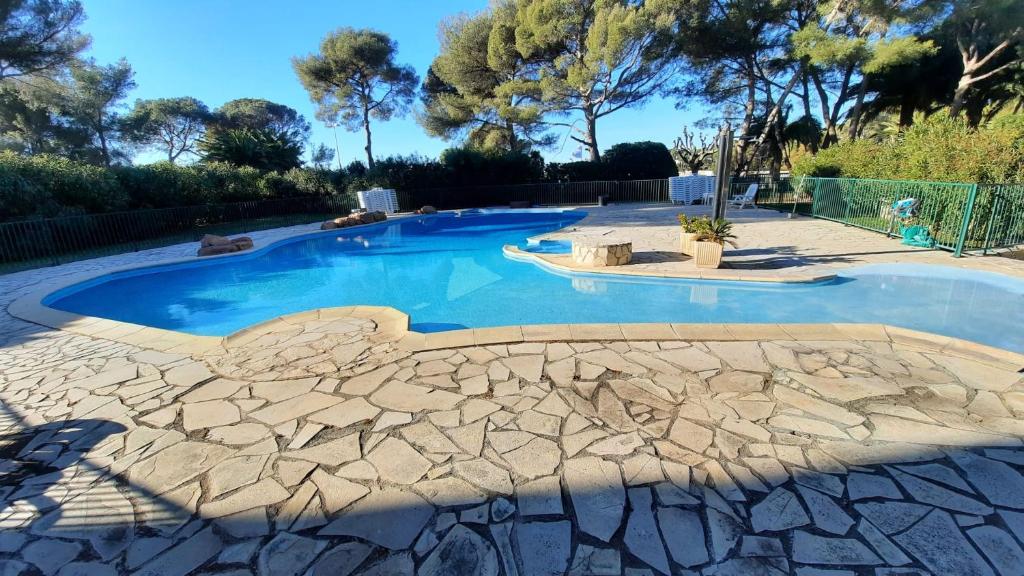 basen z kamiennym chodnikiem wokół niego w obiekcie Mediterranee Paradise w miejscowości Saint-Raphaël