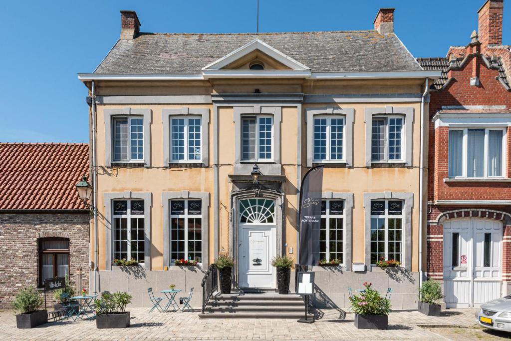 uma grande casa amarela com uma porta branca em Boutique hotel Sies em Watervliet