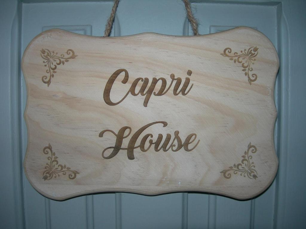 un panneau en bois avec les mots « carriole house » dans l'établissement Capri house, à Fasano