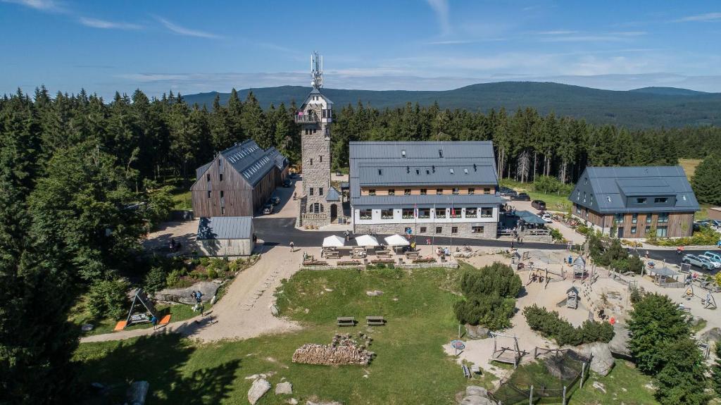 une vue aérienne sur un bâtiment avec une tour d'horloge dans l'établissement Hotel Královka, à Bedřichov