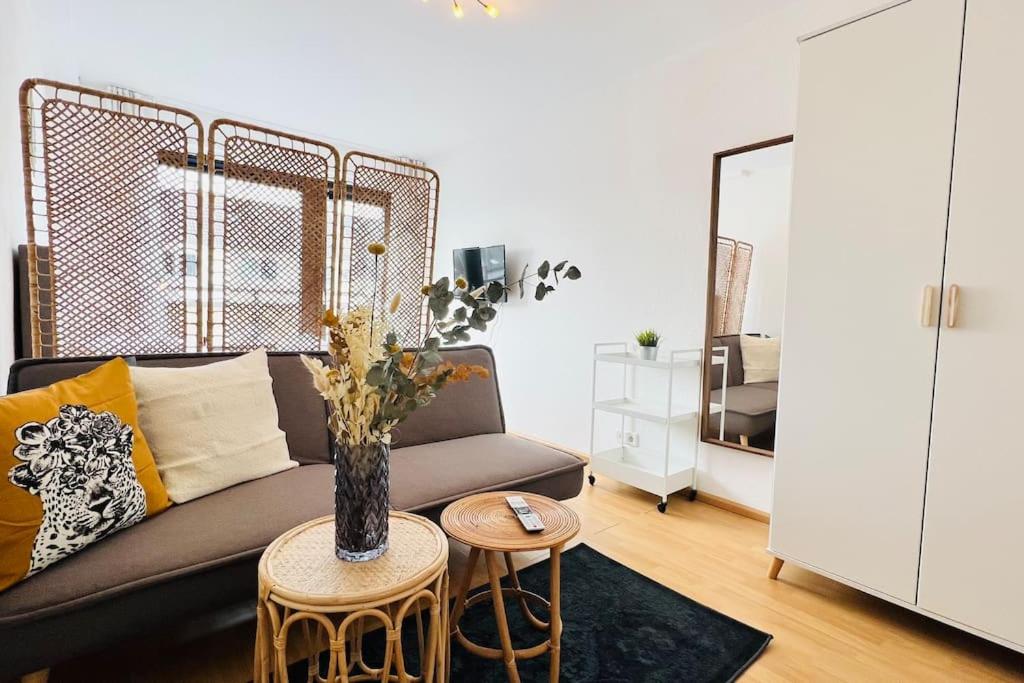 ein Wohnzimmer mit einem Sofa und einem Tisch mit einer Vase in der Unterkunft Bright Studio - Central - Balcony - Trade Fair in Düsseldorf