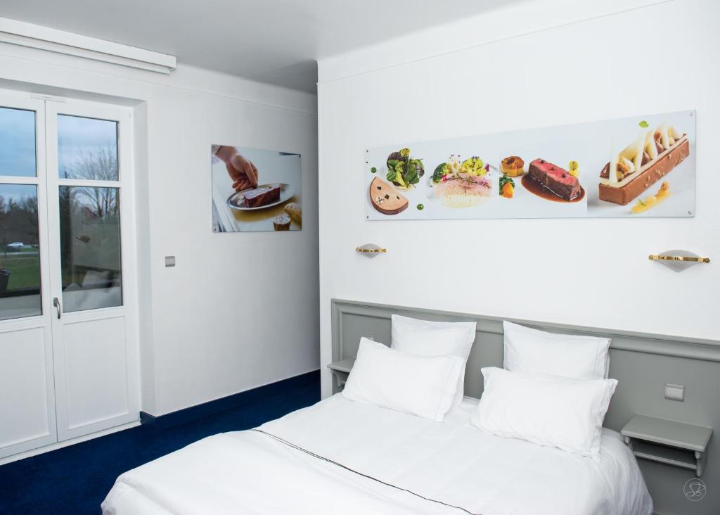 two beds in a room with white walls at Hotel restaurant au gourmet in Drusenheim