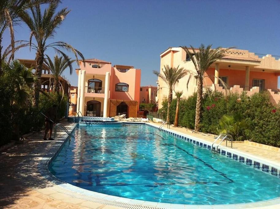 a large swimming pool in front of a building at Villa Dina in Sharm El Sheikh
