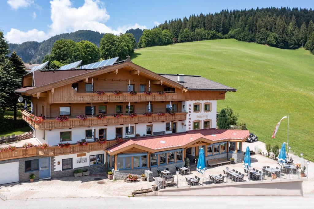 a large building with tables and chairs in front of it at Gasthof Schöntal in Oberau