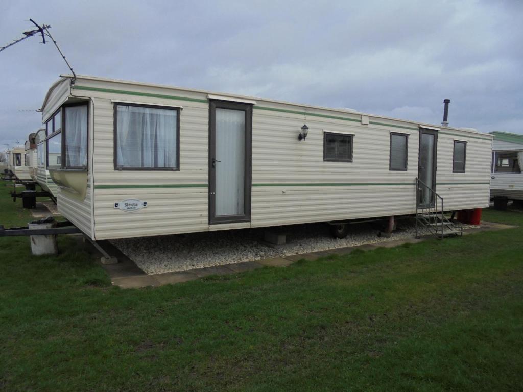 a white rv parked in a grass field at 6 Berth on Coral Beach (Carnaby Siesta) in Ingoldmells