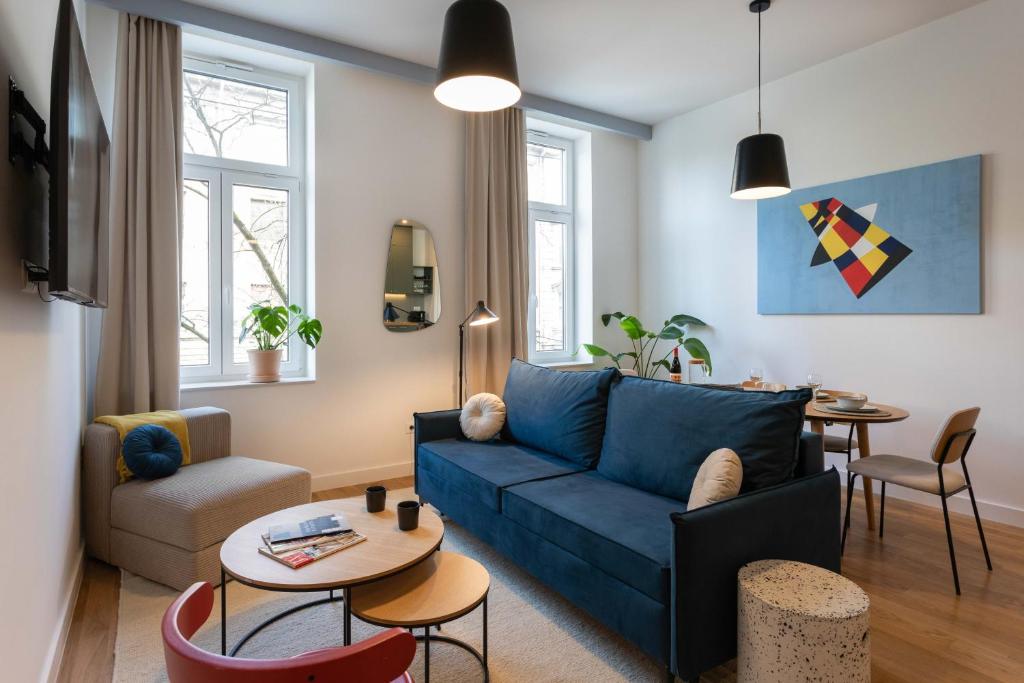 a living room with a blue couch and a table at Design Apartments near Botanical Garden in Zagreb