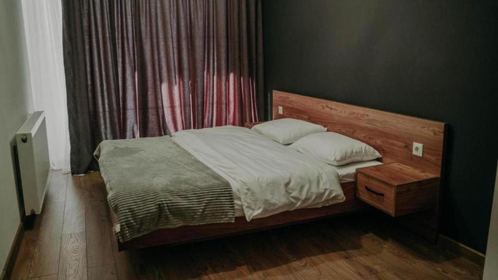 a bedroom with a large bed with a wooden headboard at Area Park Bakuriani in Bakuriani