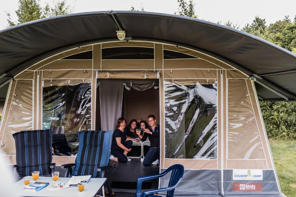 eine Gruppe von Menschen, die in einem Zelt sitzen in der Unterkunft Country Camp camping Südeifel in Irrel