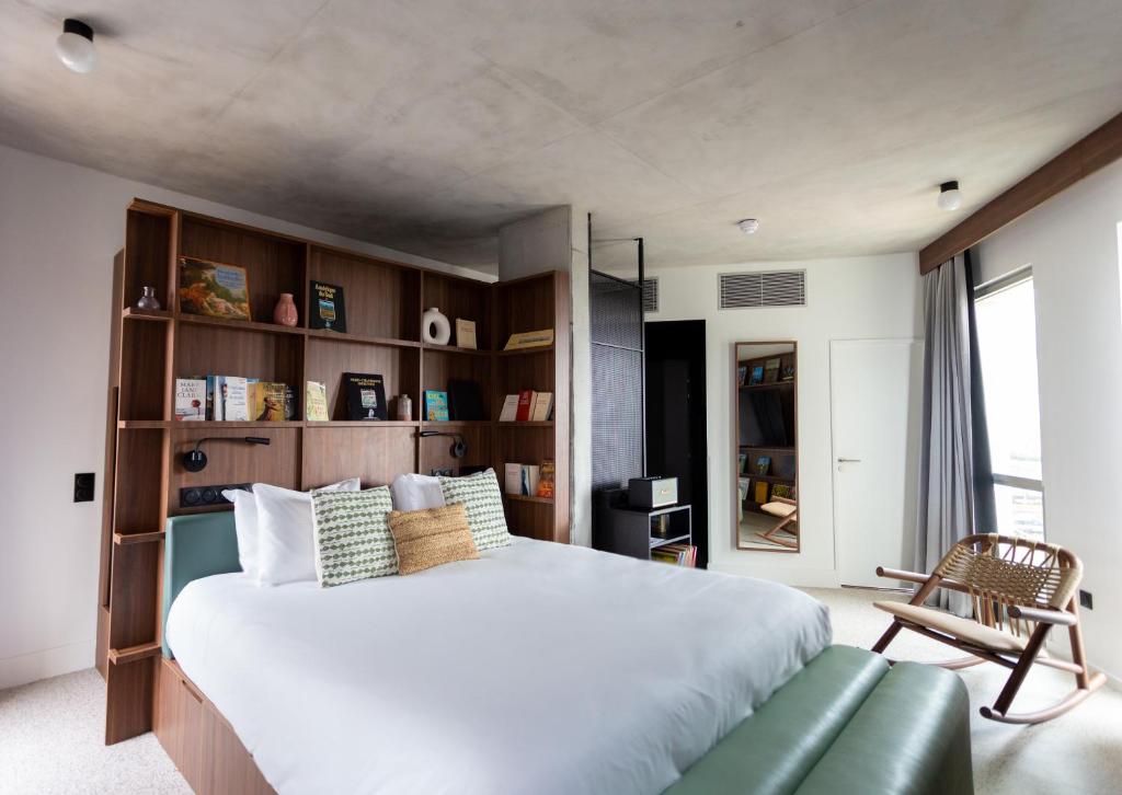 a bedroom with a large bed and a green couch at JOST Hôtel Bordeaux Centre Gare Saint Jean in Bordeaux