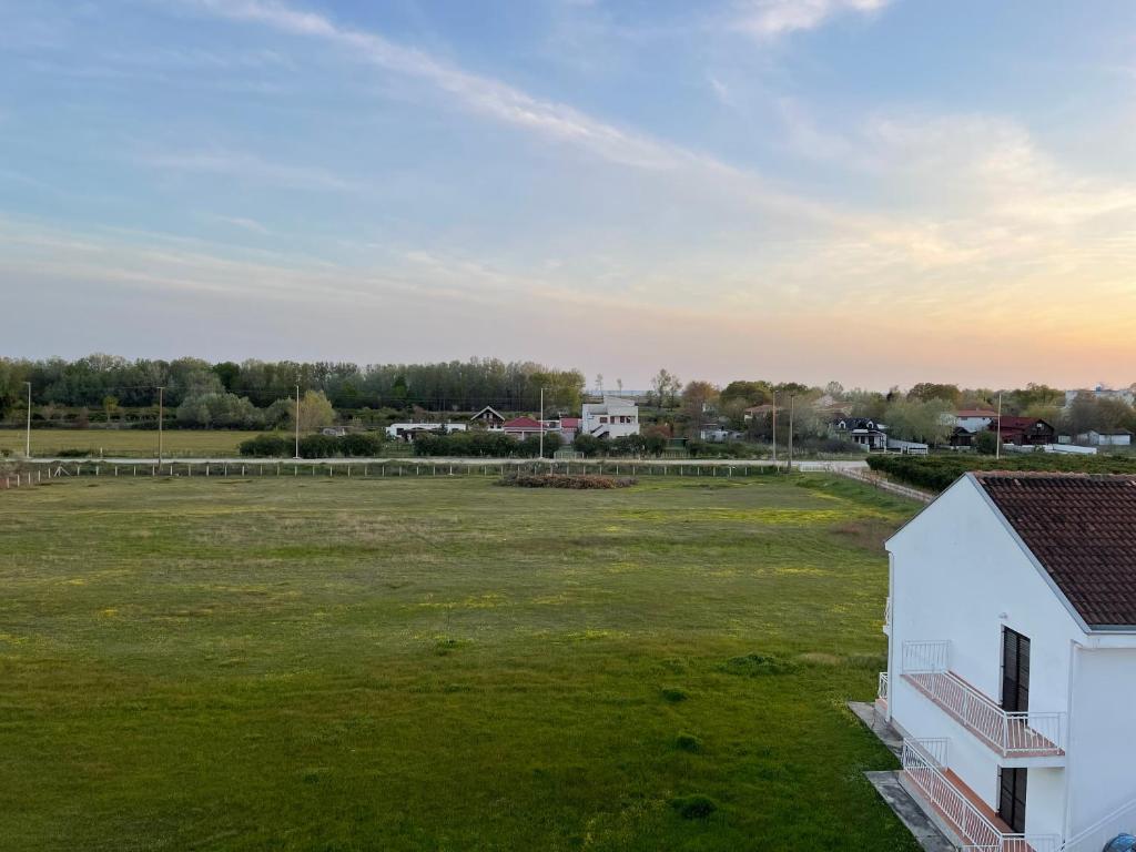 an empty field next to a white building at Vila Palace with kitchen in Donji Štoj